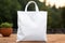 Blank White Tote Bag on Wooden Table Outdoors