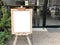 Blank wood sandwich board standing outdoor cafe. empty chalkboard for mock up menu advertising design.