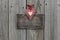 Blank wooden sign with red gingham and gold hearts hanging on wood background