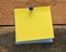 Blank yellow memo card on a wooden table. A blank space to enter a note or insert graphics