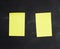 Blank yellow paper sticker glued on a black board, place for an inscription