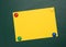 Blank yellow sheet of A4 paper hanging on a green magnetic board