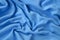 The blanket of furry blue fleece fabric. A background of light blue soft plush fleece material with a lot of relief folds