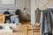 Blanket on golden chair in bright bedroom interior with grey wall