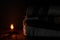 A blanket and a pillow folded in a stack on a background of fire candles in a dark bedroom