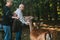 Blatna, Czech Republic, September 27, 2017: Elderly people feed deer in the forest near the park with Blatna Castle