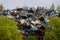 Blaydon UK: May 2022: Scrapyard. Machinery processing piles of scrap metal in a junkyard surrounded by green trees