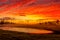 Blazing red sunrise skies across rural landscape Australia