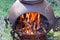 Blazing wood fire outside in a chiminea.