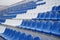 Bleachers in a sports stadium. White and blue seats in a large street stadium.