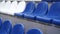 Bleachers in a sports stadium. White and blue seats in a large street stadium.