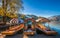 Bled, Slovenia - Traditional red, orange and blue Pletna boats in the autumn sunshine