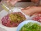 Blended food ingredients being poured on to pork slices for cooking a homemade recipe