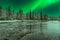 Blended image of nighttime river landscape with aurora borealis