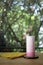 Blended pink fresh milk in tall glass, show texture of beverage