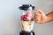 A blender filled with fresh whole fruits for making a smoothie or juice. Healthy eating concept