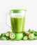 Blender with green smoothie with ingredients:  kiwi, cucumber, lime and spinach at white background. Preparing healthy juice.