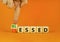 Blessed or stressed symbol. Businessman turns wooden cubes and changes the concept word Stressed to Blessed. Beautiful orange