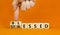 Blessed or stressed symbol. Businessman turns wooden cubes and changes the concept word Stressed to Blessed. Beautiful orange
