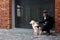 Blind caucasian man stroking guide dog, purebred golden retriever, obedient pet