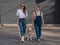 Blind caucasian woman walking with guide dog and pregnant girlfriend.