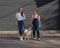 Blind caucasian woman walking with guide dog and pregnant girlfriend.