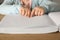 Blind child reading book written in Braille at wooden table, closeup.