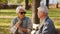 Blind elderly woman with dark sunglasses on with her husband in the park