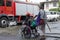 Blind man pushing wheelchair of disabled beggar
