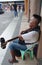 Blind Man Sits on Pavement Outside a Commercial Building and Plays Guitar in Tagbilaran City in Bohol Island, Philippines