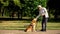 Blind man training guide dog in park, giving obedience commands, impairment