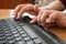 A blind man uses a computer with a Braille display and a computer keyboard. Inclusive device.