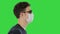 Blind man walking in medical mask and dark glasses on a Green Screen, Chroma Key.