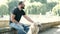 Blind mature man with guide dogs sitting on bench in park