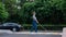 Blind pregnant woman crosses the road at a crosswalk with a cane.