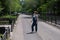 Blind pregnant woman crosses the street with the help of a tactile cane.