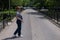 Blind pregnant woman crosses the street with the help of a tactile cane.