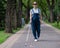 Blind pregnant woman walking in the park with a cane.