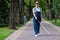 Blind pregnant woman walking in the park with a cane.