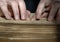 Blind reading text in braille. close-up of human hands reading b