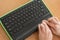 A blind woman uses a computer with a Braille display and a computer keyboard. Inclusive device.