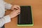 A blind woman uses a computer with a Braille display and a computer keyboard. Inclusive device.