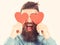 Blinded by love concept. Man with beard holds red hearts