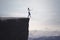 Blindfolded businesswoman walks toward cliff