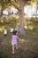 Blindfolded girl hitting pinata hanging on tree in forest