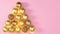 Blinking lights on Christmas tree made of gold ornament balls on pastel pink theme. Stop motion