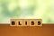 BLISS message word on a wooden desk on cube blocks with a green nature