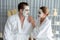 Blissful couple in bathrobe with facial cream mask. Quiescent