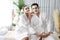 Blissful couple in bathrobe with facial cream mask. Quiescent