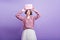 Blissful european female model holding birthday present over head and smiling. Studio shot of fascinating girl with